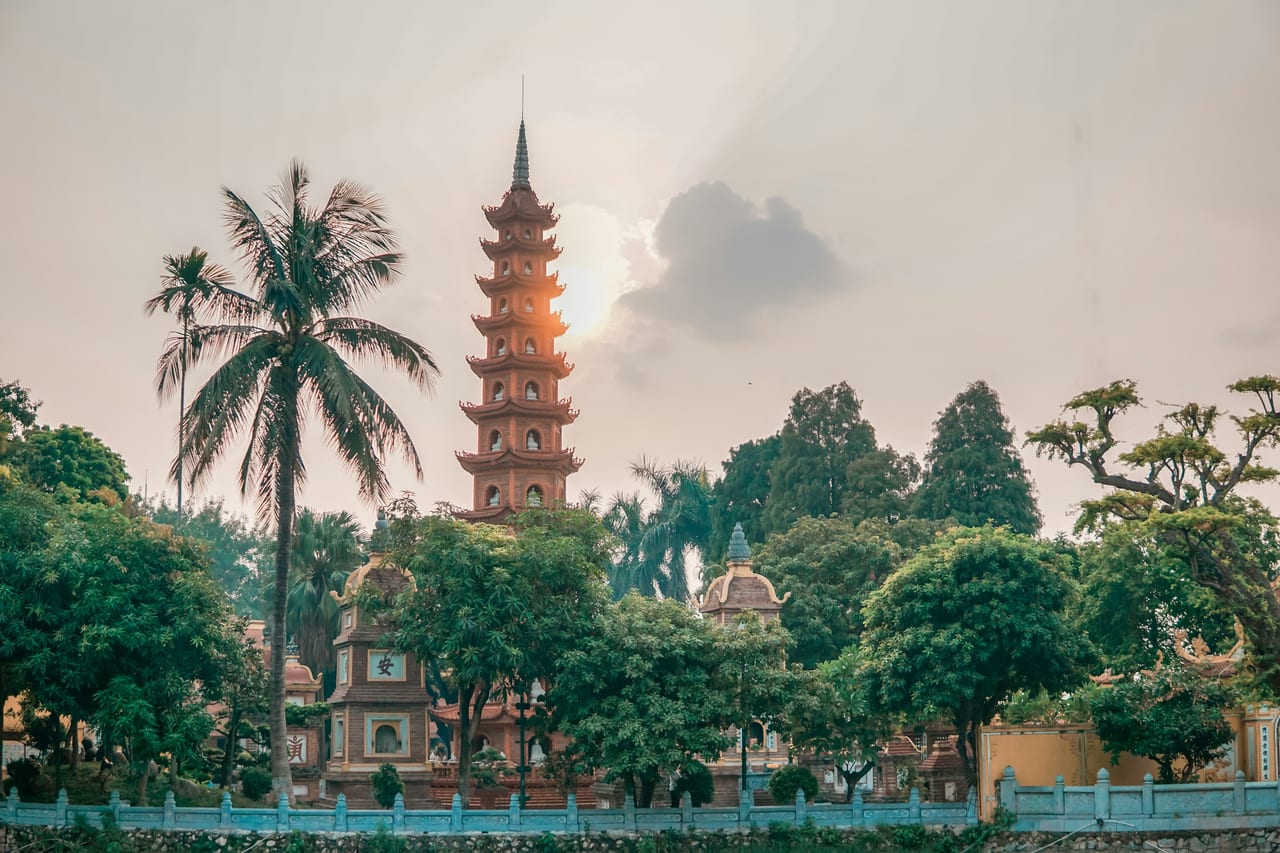 Tháp chùa Trấn Quốc nổi lên giữa hàng cây xanh và những cây dừa ở Tây Hồ, Hà Nội